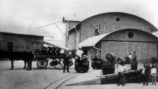 Personal de Cervecería Centro Americana, S.A. prepara un carretón para la entrega de producto terminado, c. 1915. 