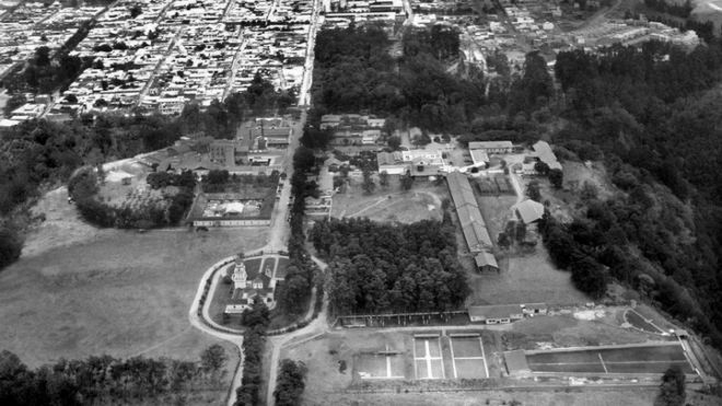 Vista aérea del norte al sur de la Ciudad de Guatemala de la Asunción. En la parte inferior se observa las instalaciones de Cervecería Centro Americana, S.A., c. 1960